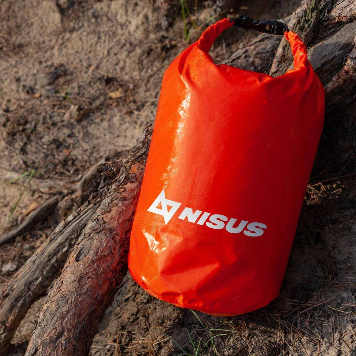 10 L Orange Polyester Waterproof Dry Bag for Fishing, Kayaking lying on the shore