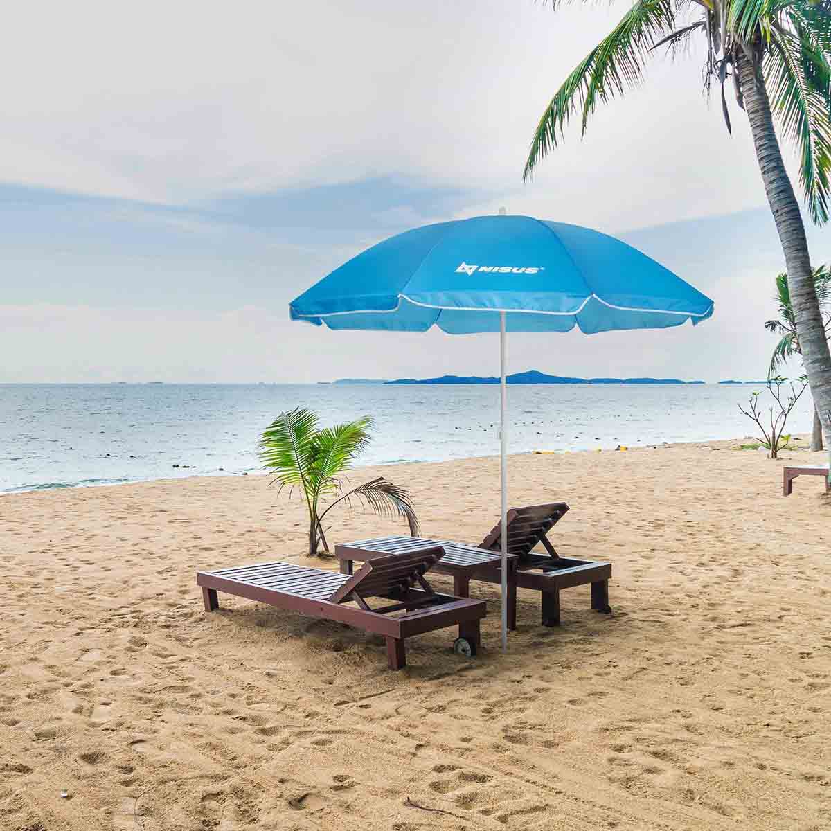 Blue Folding Beach Umbrella standing between the two loungers at the beach