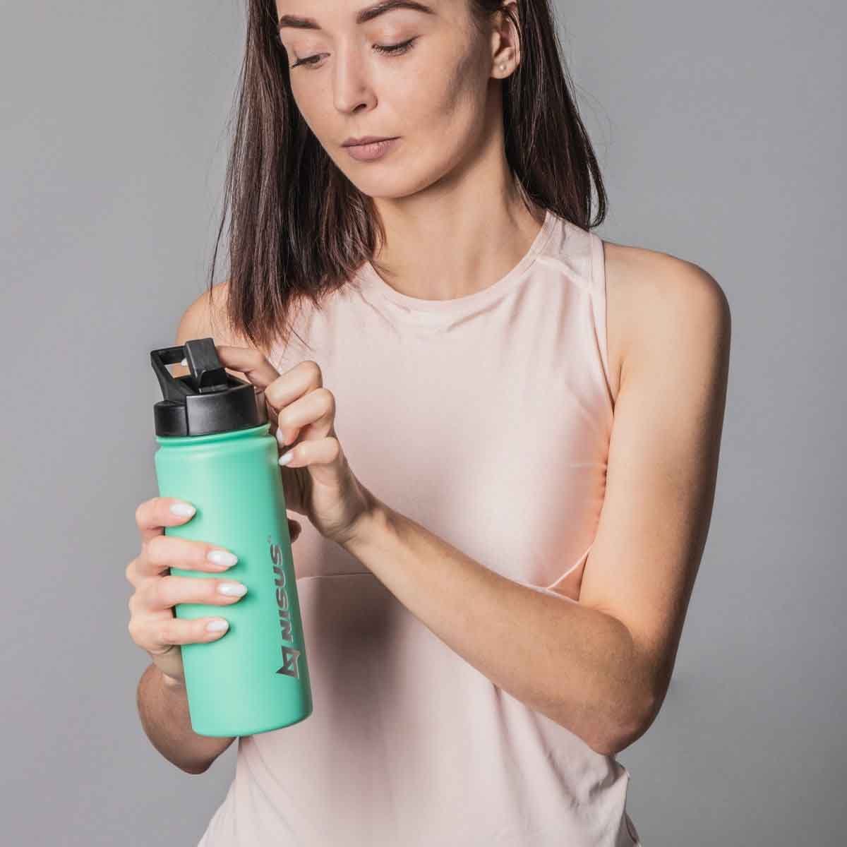 A girl holding a Stainless Steel Insulated Sport Water Bottle with 3 Lid Types, 18 oz, Turquoise