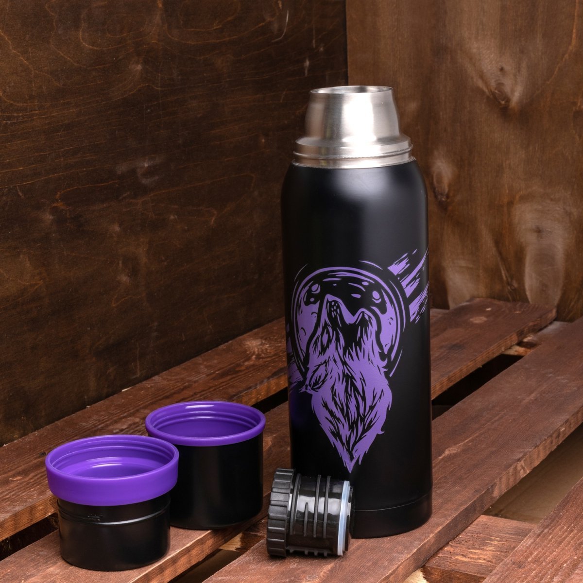 Big Stainless Steel Water Flask, Wolf Print, 40 oz standing on a wooden bench
