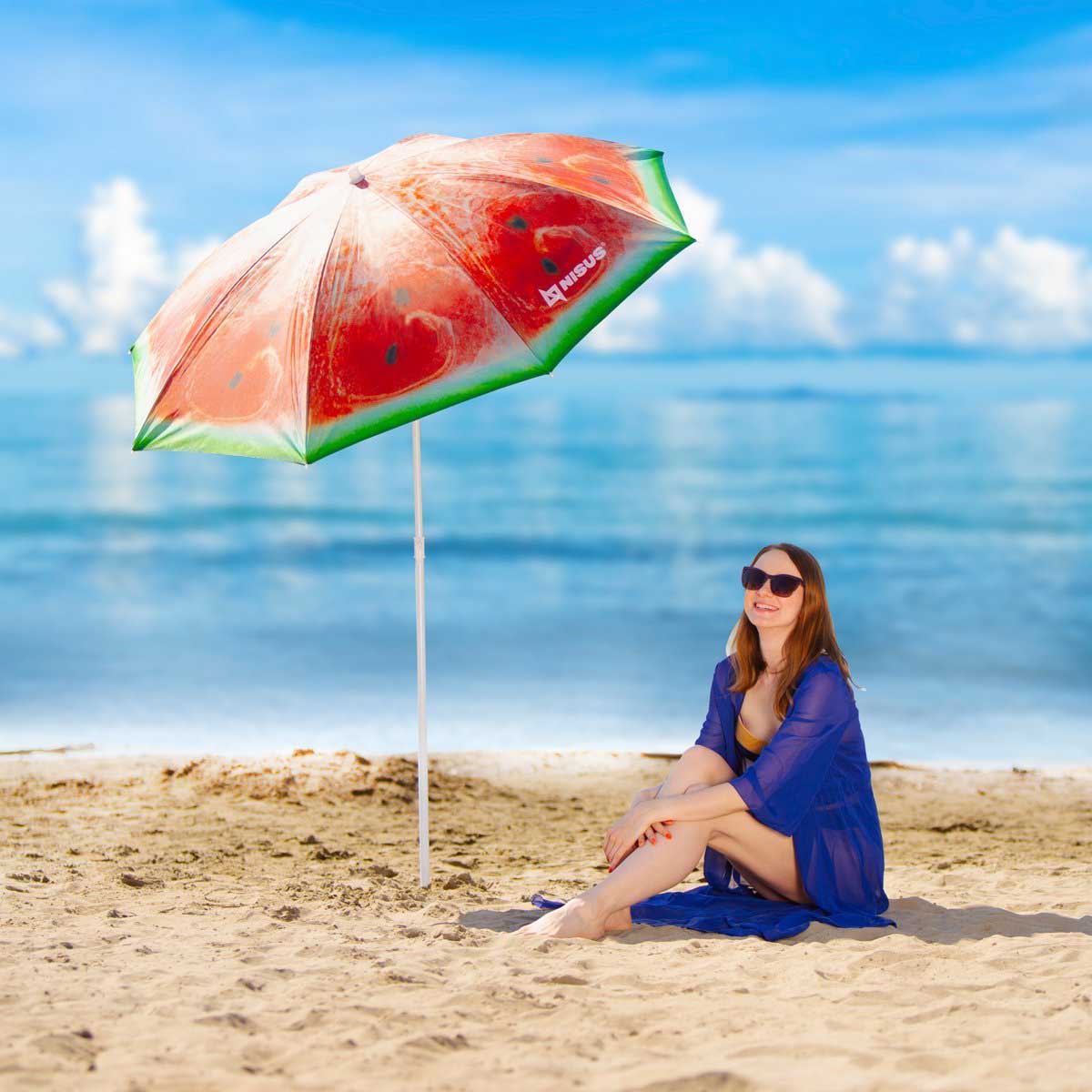 Girl sitting ion the beach sand under the Watermelon Folding Tilting Beach Umbrella