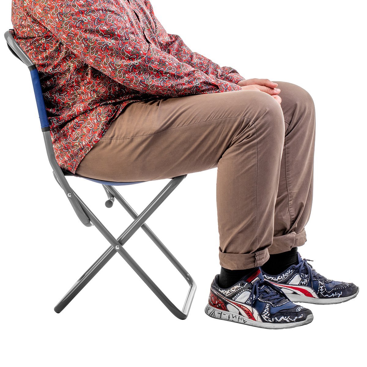 Man wearing shirt, trousers and snickers sitting on the folding camping chair with a back