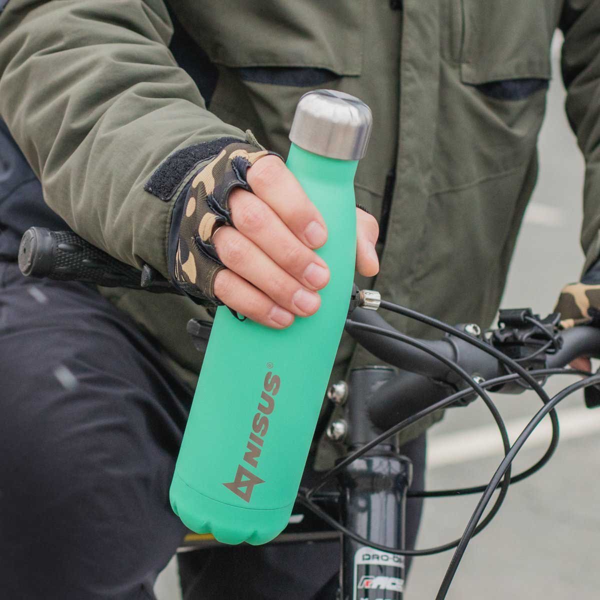 A man on the bike holding a Stainless Steel Insulated Twist Top Water Bottle, 17 oz, turquoise