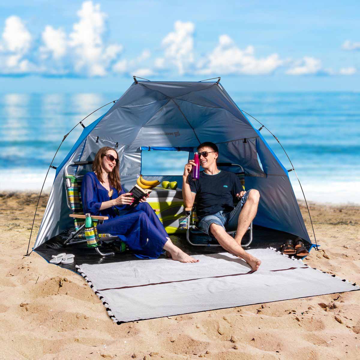 A couple sitting in the 4 Person Large Easy Up Beach Tent Sun Shade Shelter UPF 50+