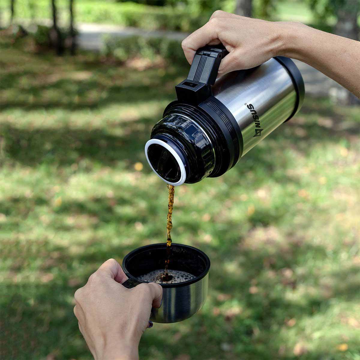 A man pouring a drink from a Double Wall Insulated Compact Vacuum Flask with Handle, 33 oz into a lid cup