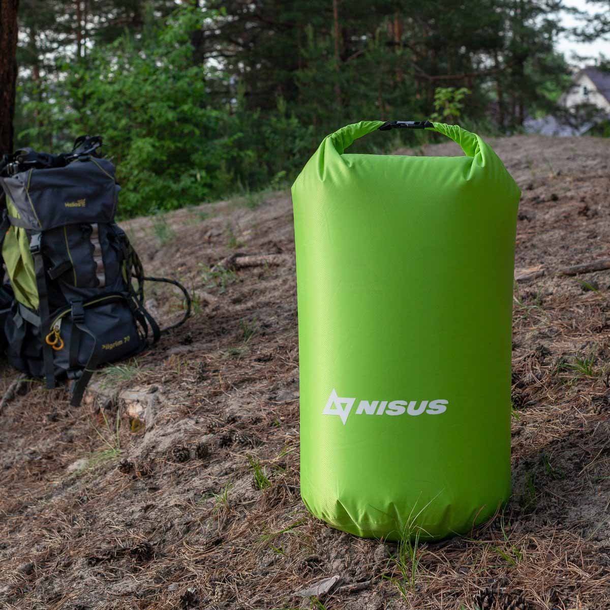 30 L Green Polyester Waterproof Dry Bag for Fishing, Kayaking staying near the TRAVEL backpack on the shore
